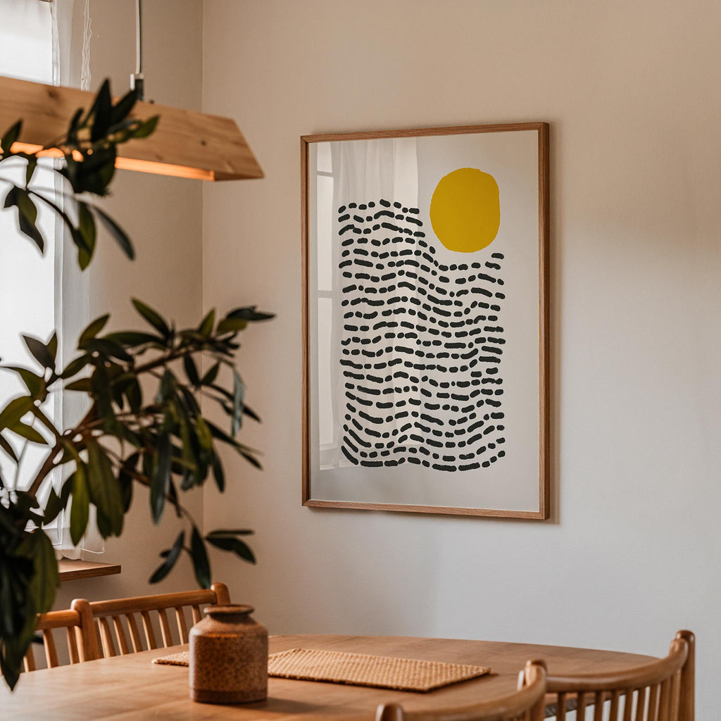 a wooden dining table with a vase on it, and a framed abstract art piece hanging on the wall above the table.