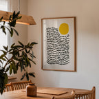 a wooden dining table with a vase on it, and a framed abstract art piece hanging on the wall above the table.