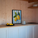 a kitchen counter with a framed painting of lemons, a bowl of lemons, and a white pitcher.