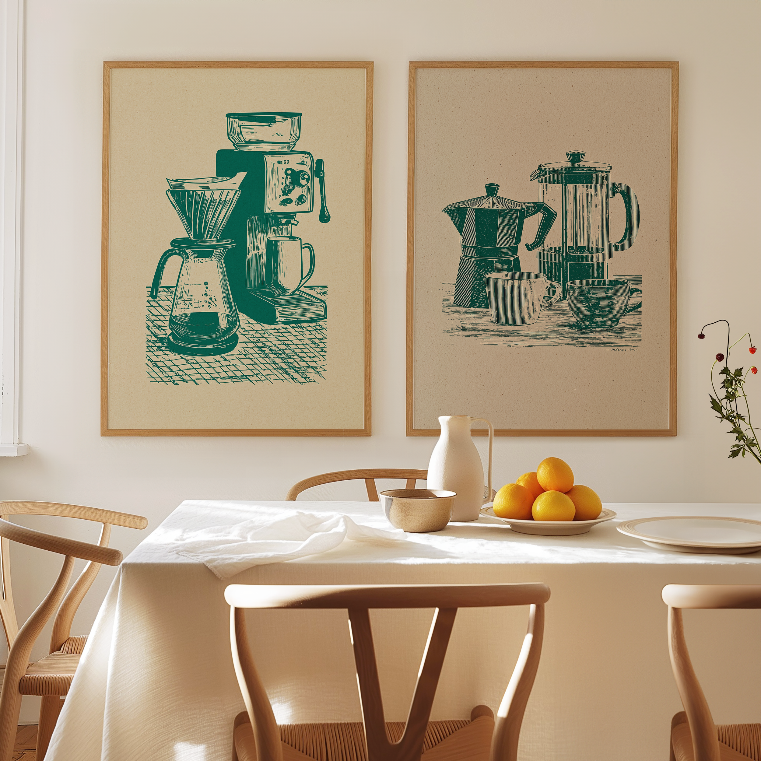 a dining table with a white tablecloth, a bowl of fruit, and a coffee maker on it. There are four chairs around the table, and two framed artworks are displayed on the wall above the table.