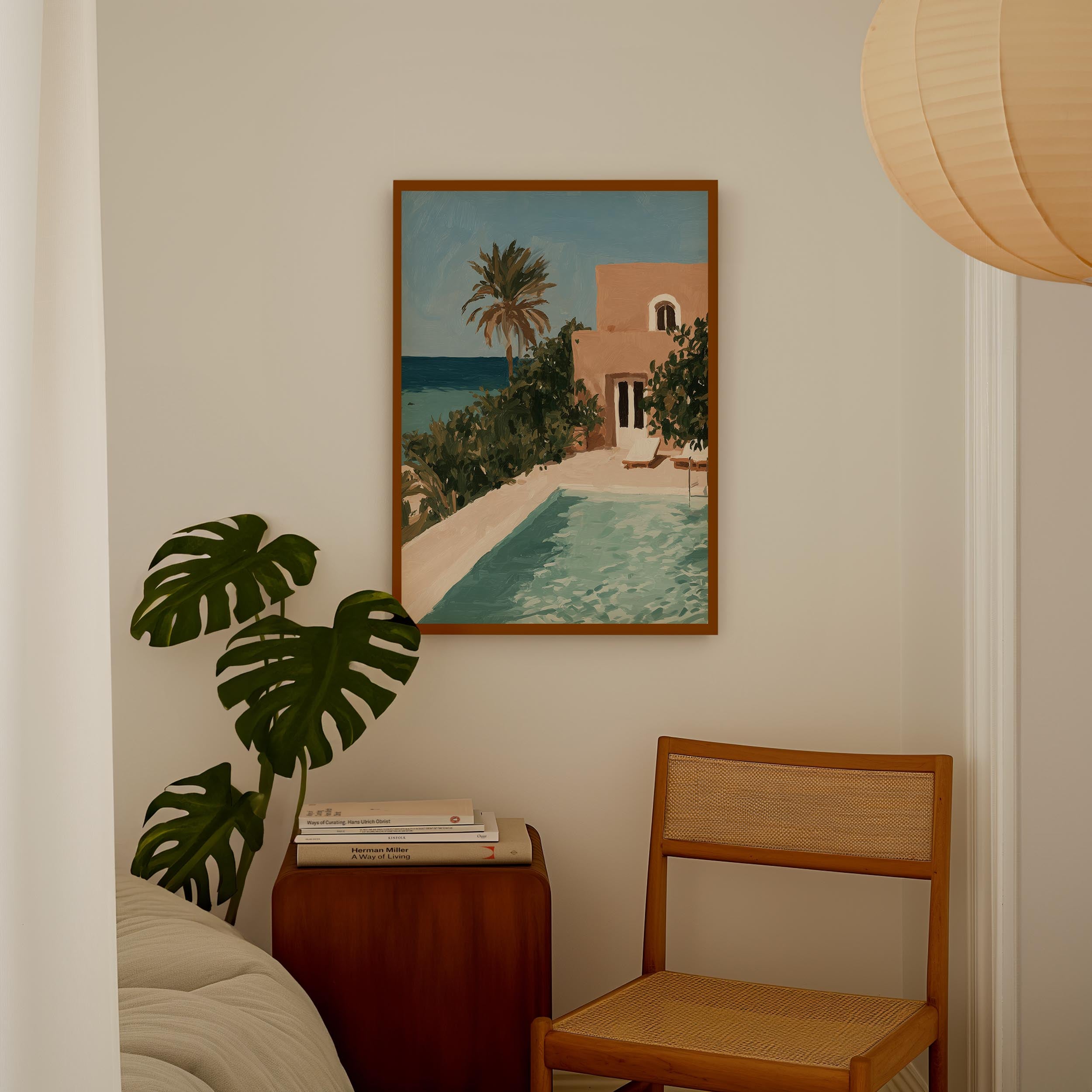a painting of a tropical beach scene with a pool and palm trees, hanging on a wall above a wooden chair and a small table.