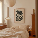 a bedroom with a bed, a lamp, and a framed artwork on the wall.