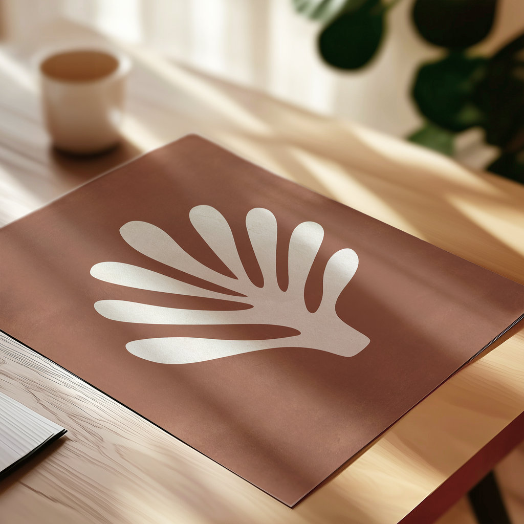 a brown paper with a white leaf-like design on it, placed on a wooden surface.
