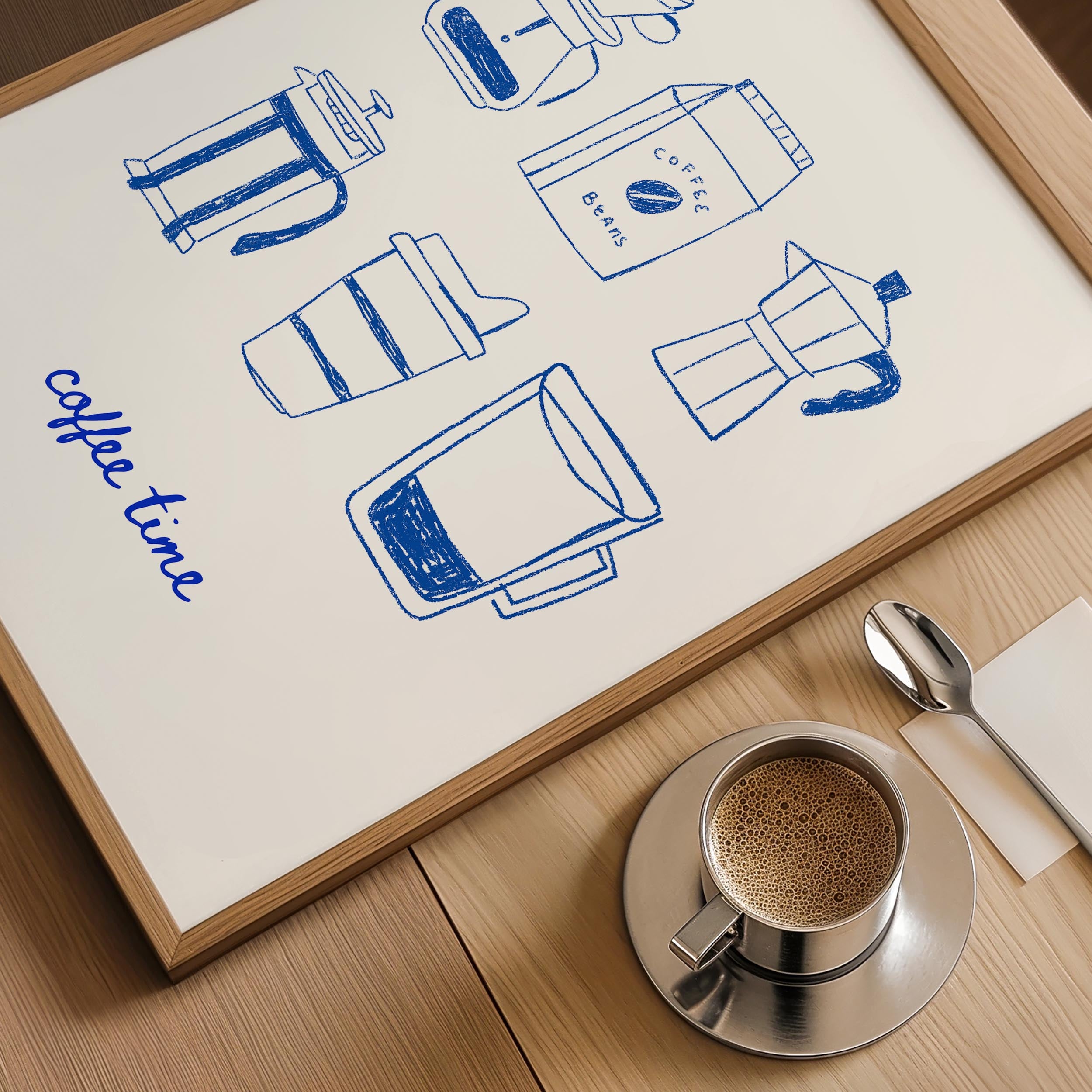 a framed poster with illustrations of coffee-making equipment, including a French press, coffee beans, and a coffee cup, along with the phrase "coffee time" written on the poster. Next to the poster is a cup of coffee and a spoon, suggesting a cozy coffee-drinking setting.