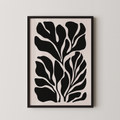 The image is a framed artwork featuring a striking black and white abstract design of stylized leaves or plant-like shapes.