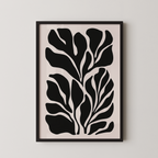 The image is a framed artwork featuring a striking black and white abstract design of stylized leaves or plant-like shapes.
