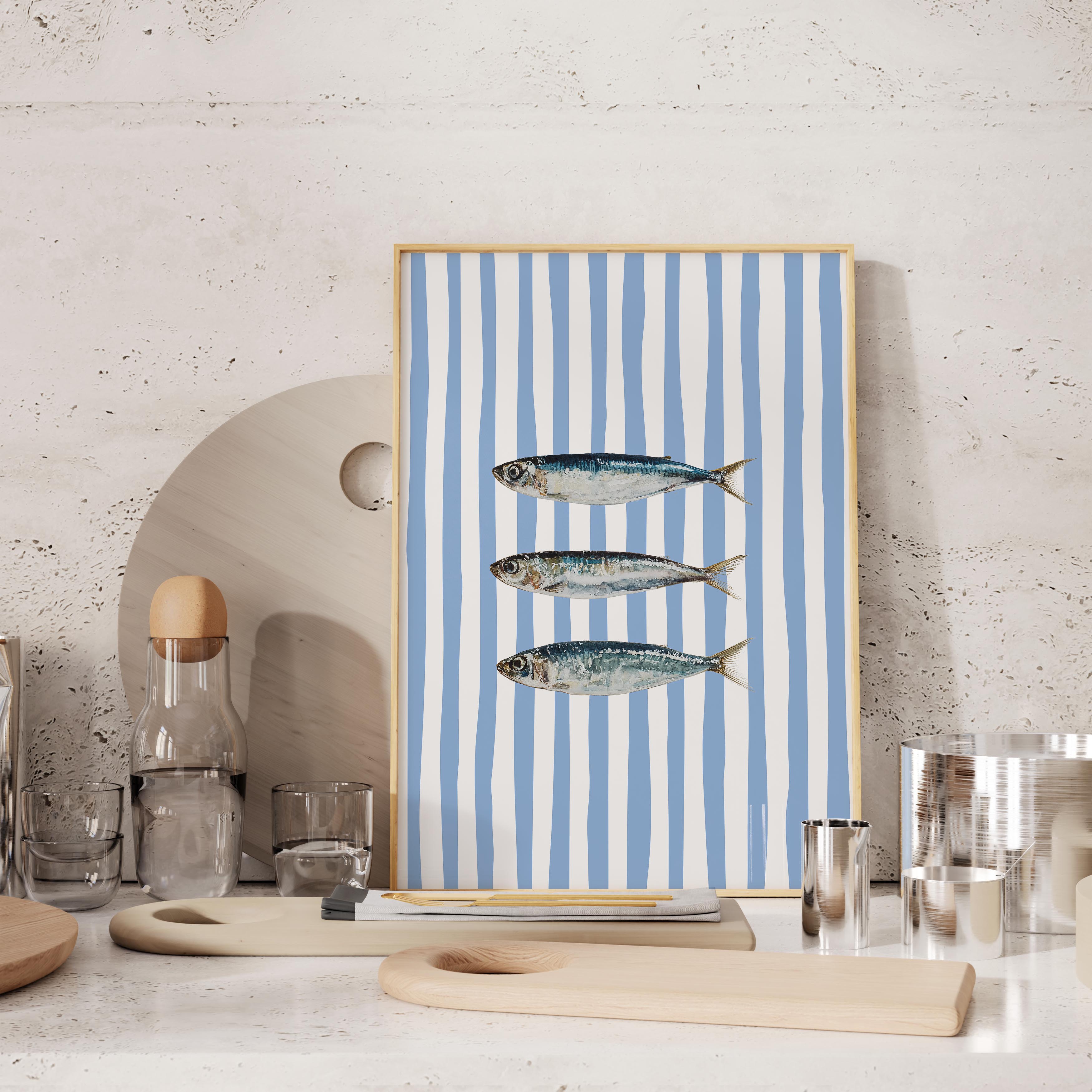 a framed artwork of three fish on a blue and white striped background, placed on a shelf or table.